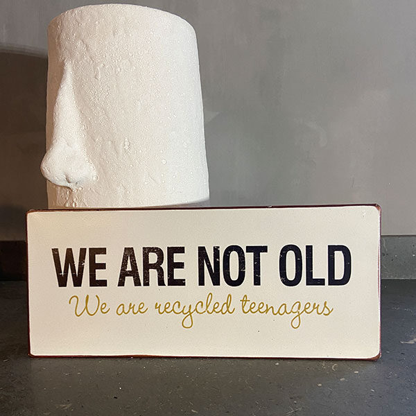Plåtskylt med text, we are not old