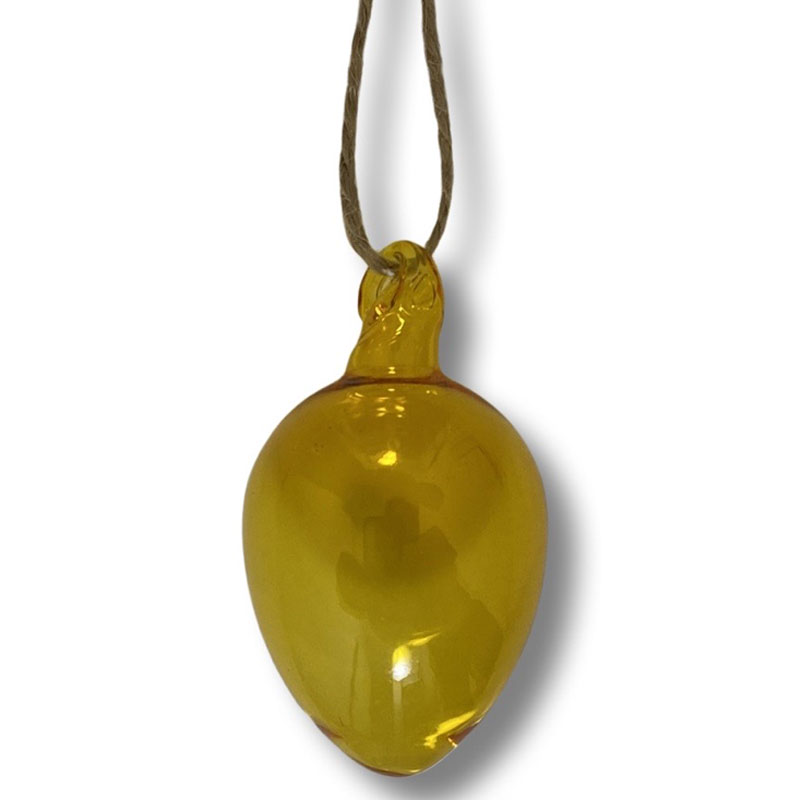 Gult ägg i munblåst glas.