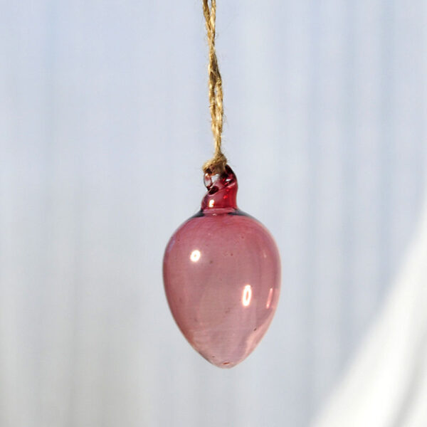 Glasägg i munblåst rosa glas som hänger i ett snöre av jute.