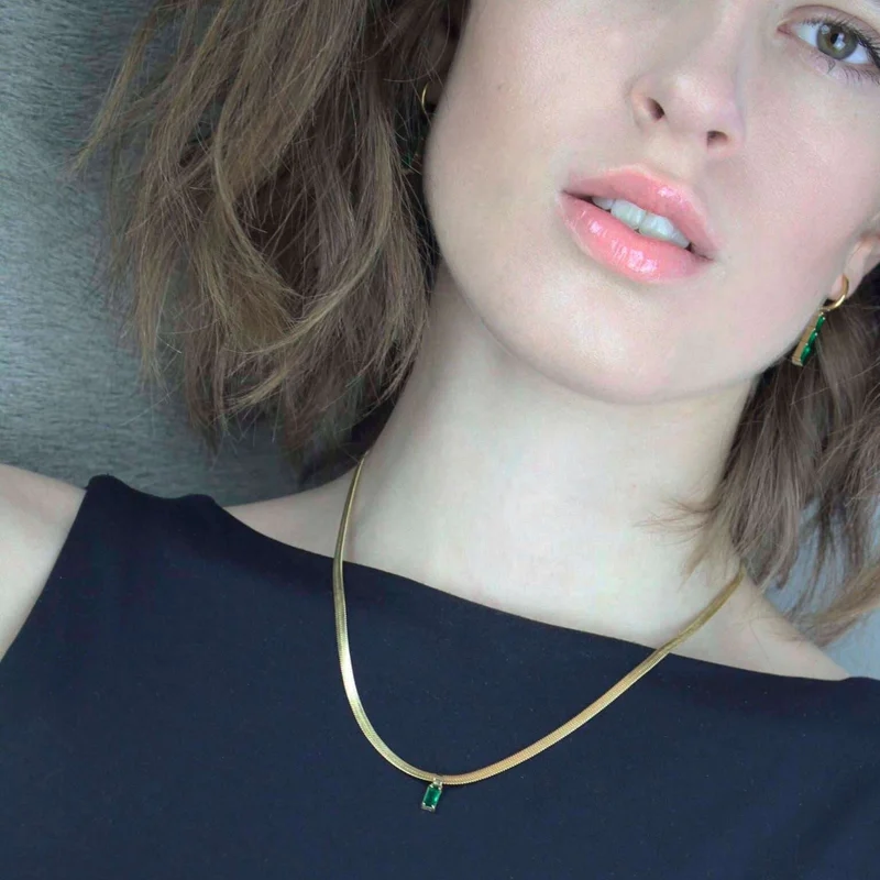 Snake chain halsband med en grön kristall.