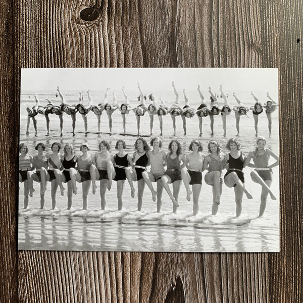 Vykort med svartvitt motiv från 1930-talet som föreställer Tiller Girls som dansar på stranden.
