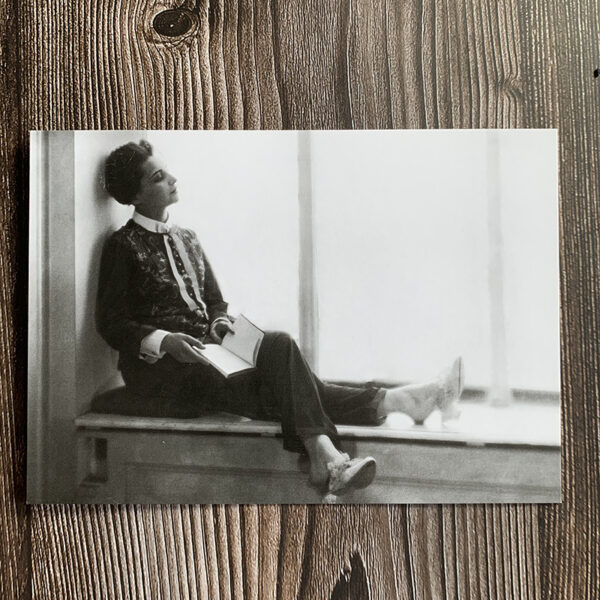 Svartvitt kort med motiv från 30-talet som föreställer en kvinna som sitter i ett fönster och reflekterar över livet.