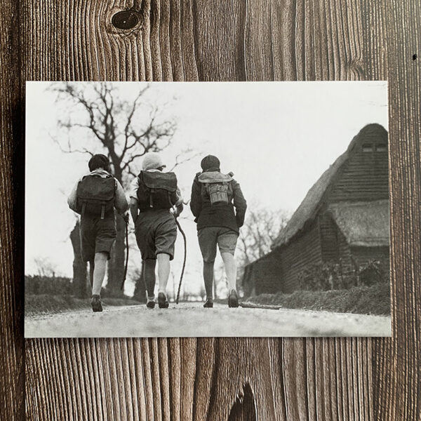 Svartvitt kort med motiv från 30-talet som föreställer tre vandrande vänner.