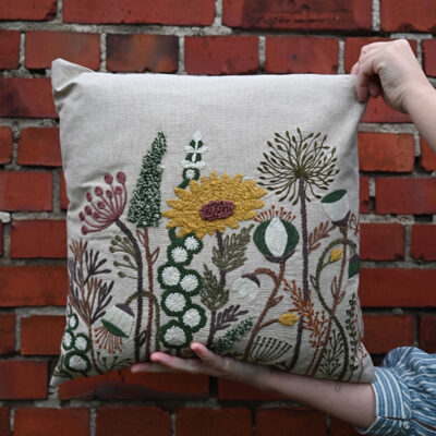 Kuddfodral från Miljögården, Helianthus naturfärgad med broderade blommor.